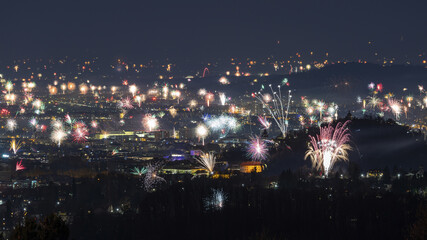 View of a dazzling display of fireworks erupting across the cityscape, illuminating the night sky with vibrant colors and festive cheer, Graz, Styria, Austria.