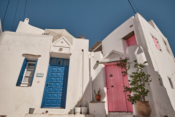 Case bianche di Paros con porte colorate: architettura tradizionale greca sotto il cielo estivo.
