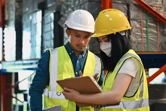 Industrial supervisor and worker discussing document details to ensure operational accuracy
