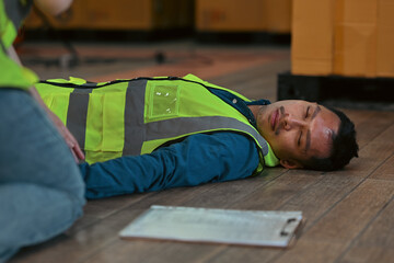 Industrial accident scenario showing a fallen worker on the warehouse floor, emphasizing safety risks and the importance of immediate medical assistance