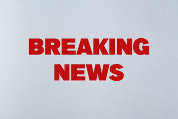Breaking News Sign in Bold Red Text on a Light Background