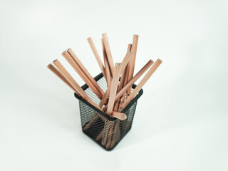 Pencils in a stylish black mesh holder on a white background, ready for creative projects