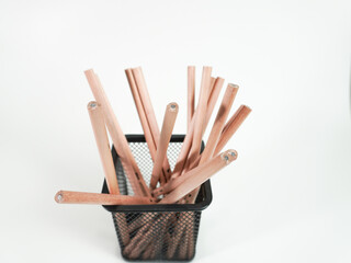 Wooden pencils in a black mesh container ready for writing and creative projects on white background
