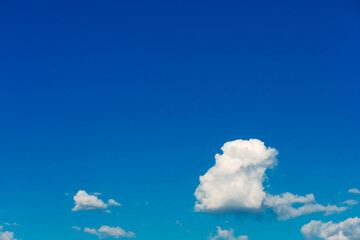 Clear blue sky with fluffy white clouds creating a feeling of calm and serenity.