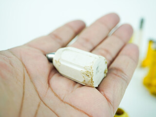 Holding a small, worn amulet in hand, symbolizing protection and good fortune for travelers