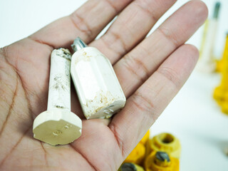 Hand holding damaged electrical components, highlighting industry wear and tear for technical...