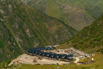 Scandinavian alpine A-frame houses, chalets and stilt structures under construction in mountainous....