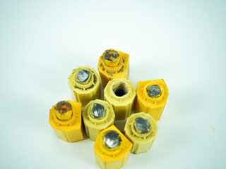 Isolated yellow industrial components with metal inserts, suggesting manufacturing or machinery...