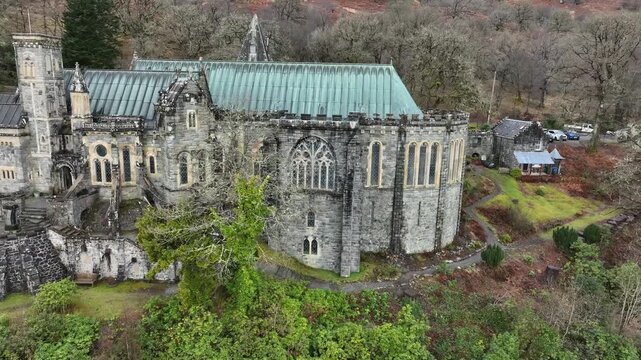 Aerial view of St Conan's Kirk, with its grey stone walls standing in stark contrast to the green foliage surrounding it, Dalmally, United Kingdom.