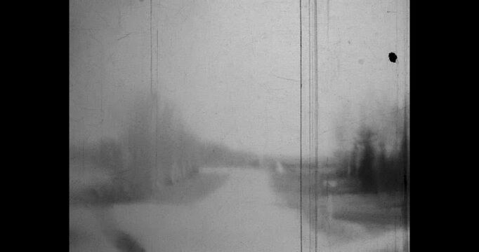 Driving along a road with a rural landscape, fields and trees, empty road, black and white film. Archival video, 1970s, Belarus