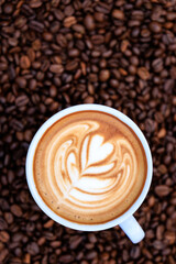 cappuccino white cup and roasted coffee beans backgrounds abstrack, top view