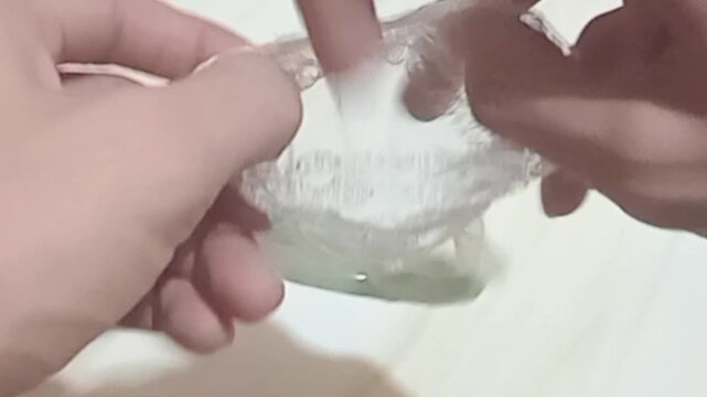 4K close-up video of hands unboxing and presenting a beautiful jade bangle bracelet on a soft background. Perfect for jewelry, fashion, accessories, luxury product, and lifestyle themes.