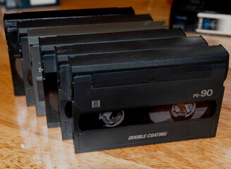 8mm video tapes from the early 90s arranged on a wooden table