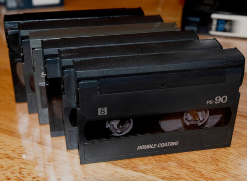 8mm video tapes from the early 90s arranged on a wooden table