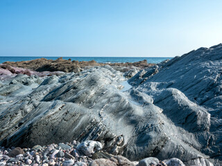 colorful rocks on south coast in cornwall under blue sky