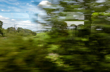 Travel by train through green countryside