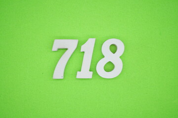 The numbers are made of white painted wood and placed on a green paper background.