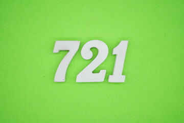 The numbers are made of white painted wood and placed on a green paper background.