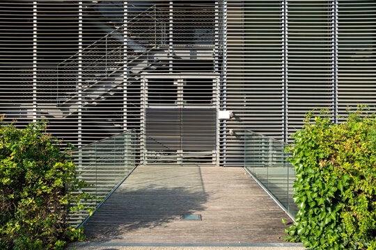 Architectural urban entrance with layered stairs and shadows framed by vegetation, useful for contemporary mobility, public access design, and modern infrastructure-focused branding visuals.