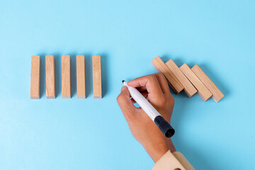 Business Hand Using Pen To Stop A Domino Effect, Creative Metaphor For Strategy