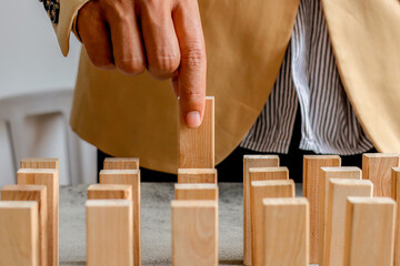 Hand Stops Wooden Domino From falling
