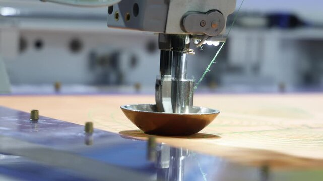 Sewing automate robot. Close up of industrial embroidery or sewing machine precisely stitching patterns onto fabric. Advanced automation in textile production and needlework with high technology.