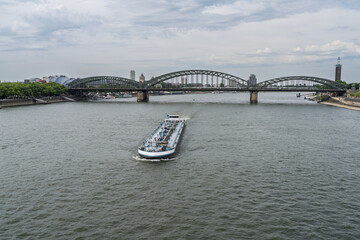 Cargo Tanker Ship Passing Through Large Hohenzollern Bridge Over a Calm Wide Rhine River in Cologne City, Germany