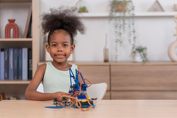 portrait african elementary school age girl working on robot circuit on table,homework,casual learning at home,STEM education