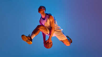 Basketball athlete executing aerial maneuver against vibrant backdrop. Concept of streetball...