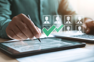 Fototapeta premium Human resources professional reviewing candidate profiles on a tablet with checkmarks