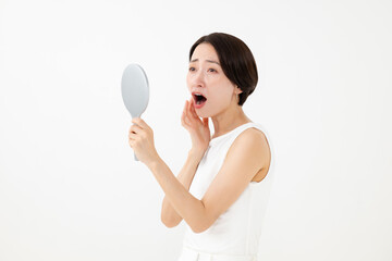 鏡を見て驚く女性