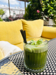 Green Cocktail with Fresh Mint on Garden Patio. Summer Season Green Drink in a glass with a straw