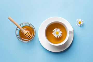 Chamomile tea cup with honey and chamomile flowers