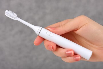 Electric toothbrush held in hand with soft-focus background highlighting its sleek design and functionality for effective dental care