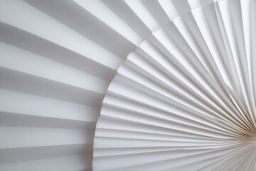 Curved white paper fan structure with elegant folds creating a modern aesthetic in a minimalistic setting