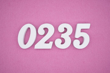 The numbers are made of white painted wood, placed on a pink paper background.