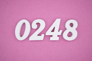 The numbers are made of white painted wood, placed on a pink paper background.