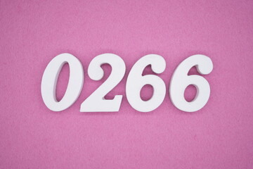 The numbers are made of white painted wood, placed on a pink paper background.