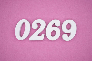 The numbers are made of white painted wood, placed on a pink paper background.