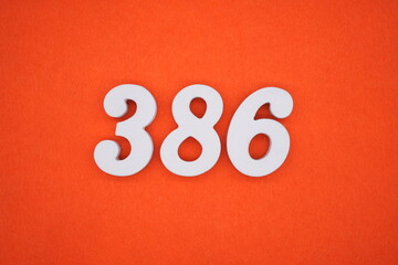 The numbers are made of white painted wood placed on an orange paper background.