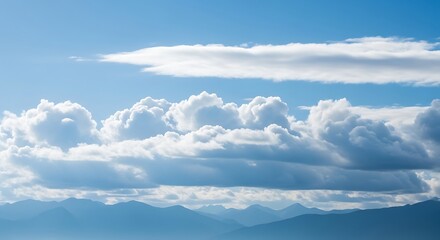 Fototapeta premium Serene mountain range beneath a calming blue sky dotted with fluffy clouds