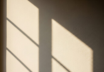 Morning sunlight streaming through a window, casting an abstract shadow on a textured wall