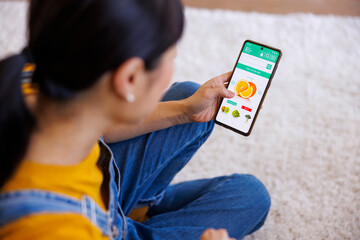Woman doing online grocery shopping using smart phone