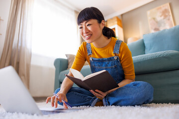 Woman taking notes while doing an online course