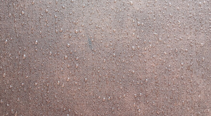 Water droplets on rusty brown metal surface