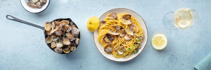 Vongole clams with spaghetti pasta, with white wine, overhead flat lay shot with lemon and thyme. Seafood linguine panorama