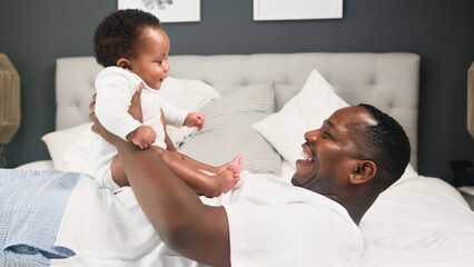 Father and Baby Joyfully Bonding Together on a Cozy White Bed in a Homey Bedroom Setting