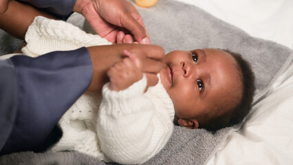 Parent Dressing an Infant on a Soft Surface During a Calm Moment in a Comfortable Setting
