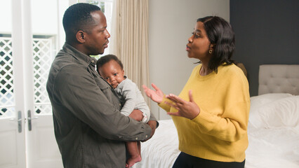 Parents Argue at Home While Holding a Baby in a Well-Lit Bedroom