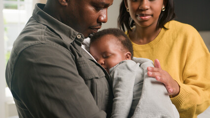 Loving Family Moment With a Father, Mother, and Baby at Home, Highlighting Parenthood and Bonding